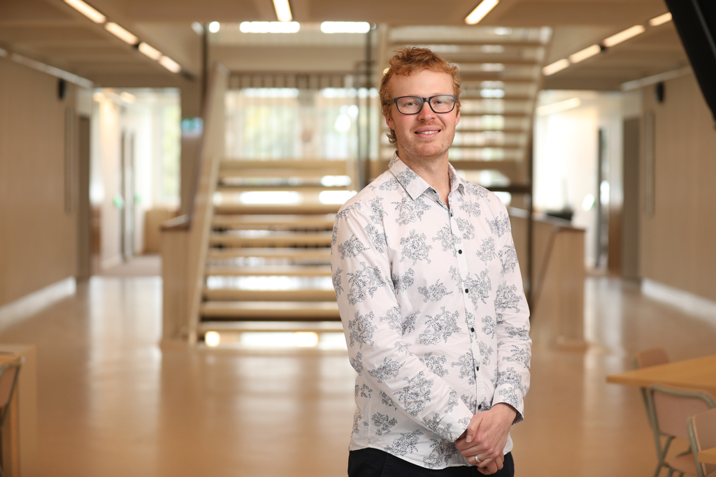 Ben headshot (wide) near the stairwell in the ANU Birch buidling