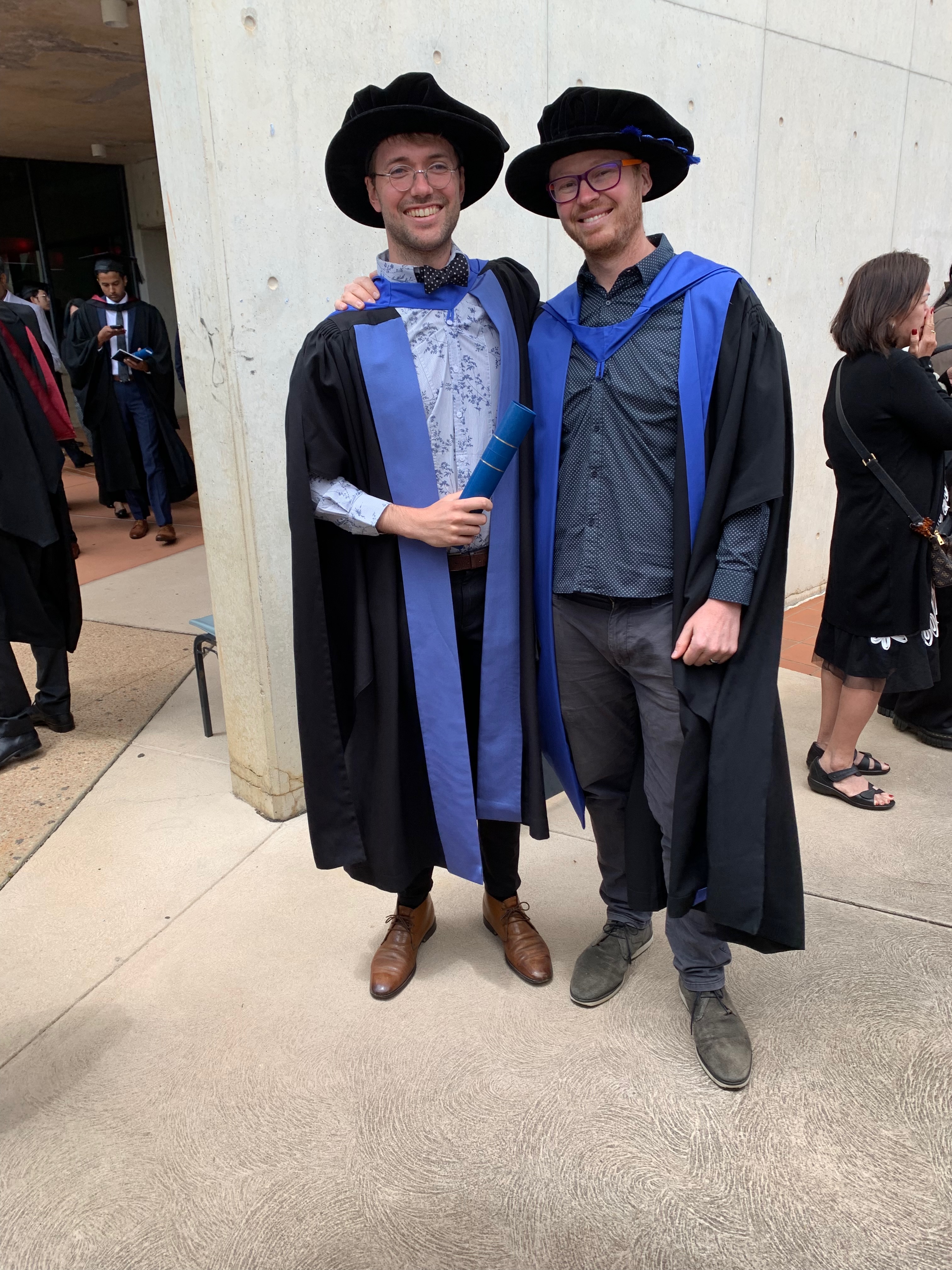 Ben and Kieran in full academic dress at the ANU graduation ceremony in December 2022